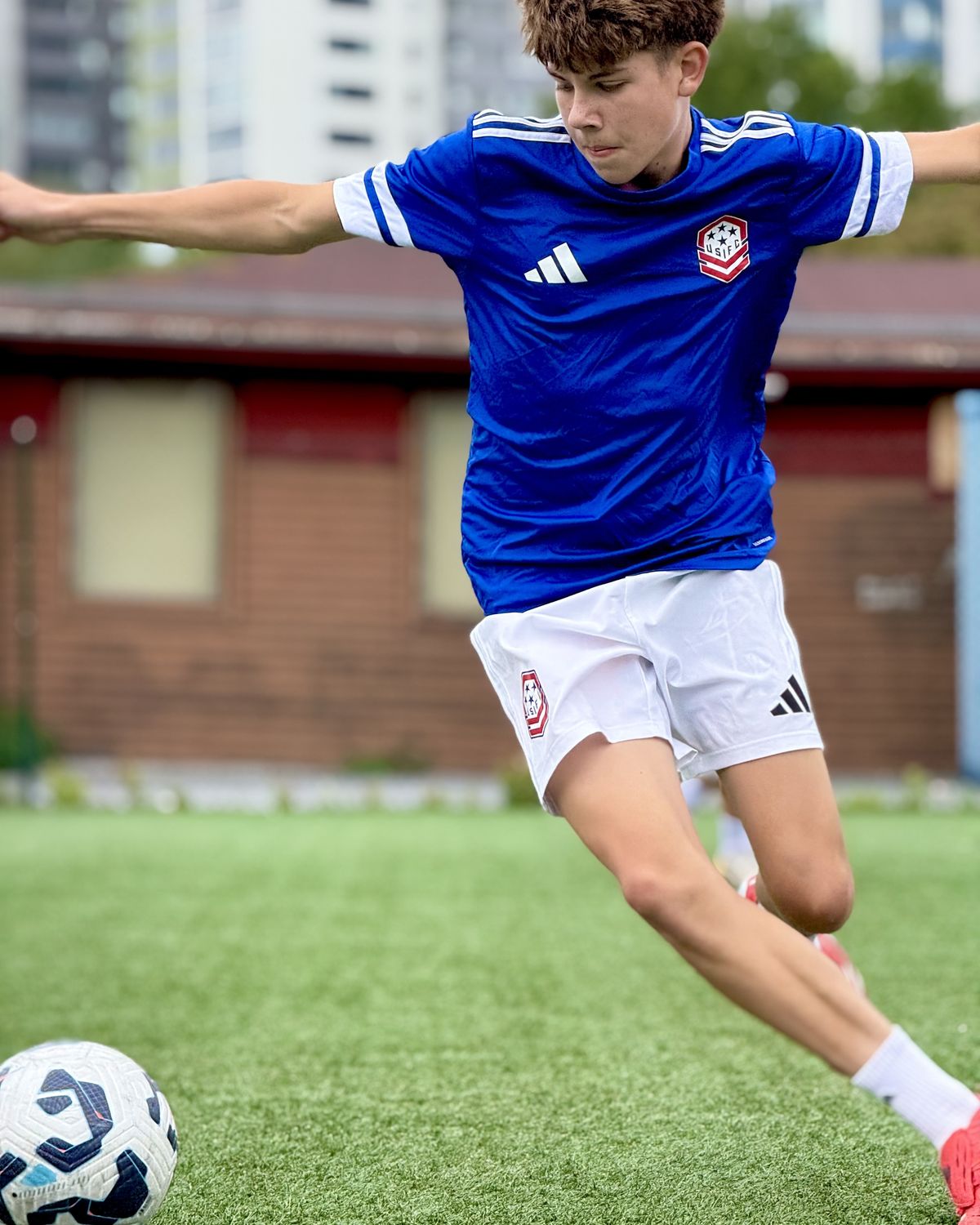 A USIFC player in blue strikes the ball